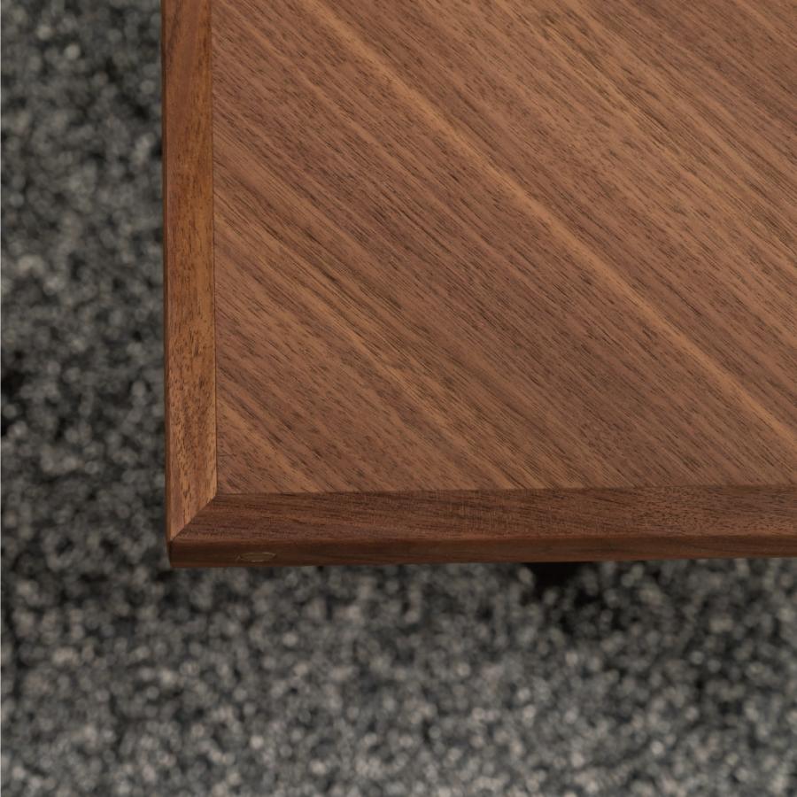 木目の向きを変えて貼り合わせた矢張りデザインと側面に施した真鍮がアクセントになるリビングテーブル